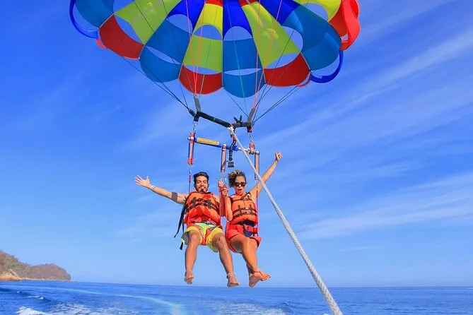 Parasailer soaring 300 feet above the turquoise Caribbean coastline on a parasailing adventure in Punta Cana, Dominican Republic