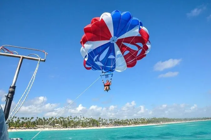 Parasailer flying high above the Bávaro beach on the top-rated parasailing tour in Punta Cana with free hotel pickup, Dominican Republic