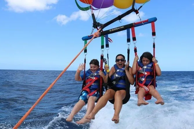 Parasailer over the coral reef coastline on an exclusive private parasailing experience in Punta Cana, Dominican Republic with bird's-eye beach views